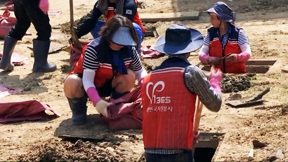 거제 수해 복구 현장에서 자원봉사자들이 흙을 퍼내는 모습 (JTBC 보도 화면)