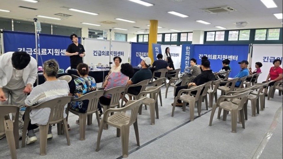 ‘긴급의료지원센터’ 현수막이 걸린 진료 공간에서 주민들이 의자에 앉아 진료를 기다리는 모습