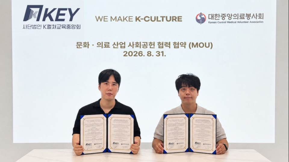 K컬쳐교육중앙회와 대한중앙의료봉사회 대표가 ‘문화·의료 산업 사회공헌 협력 협약(MOU)’ 화면 앞에서 협약서를 들고 있는 모습